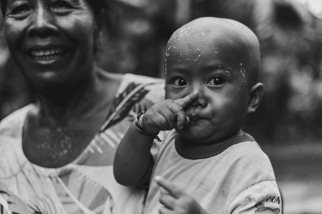 Black and white photo capturing a joyful moment between a child and an elderly woman.